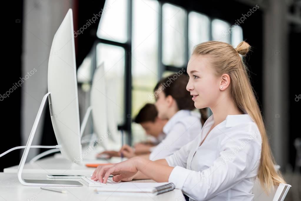 smiling teen girl working on computer