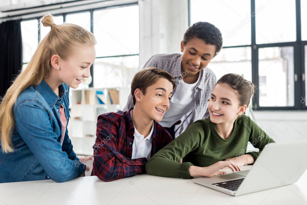 multiethnic teenagers using laptop