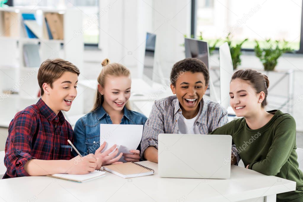 multiethnic teenagers using laptop