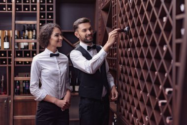 sommeliers choosing wine in cellar clipart