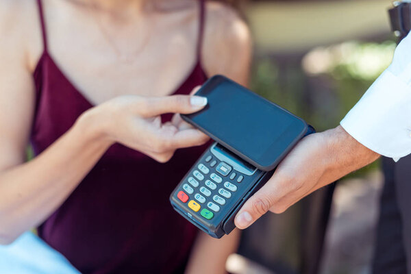 woman paying with NFC technology