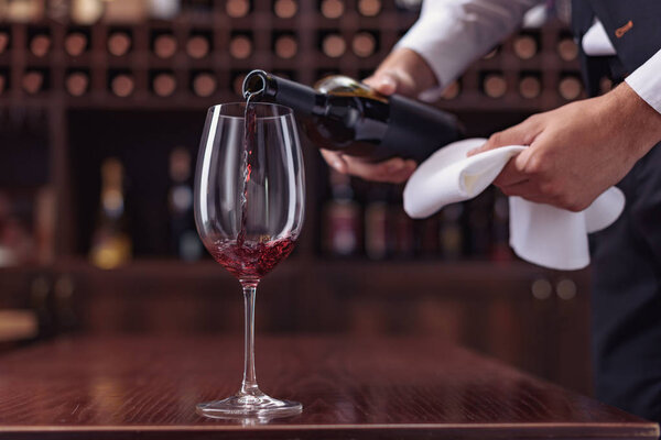 sommelier pouring red wine