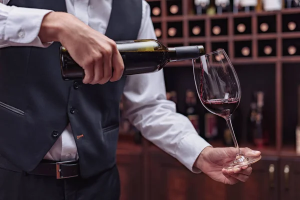 Sommelier derramando vinho tinto — Fotografia de Stock