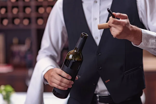Официант открывает бутылку вина — стоковое фото
