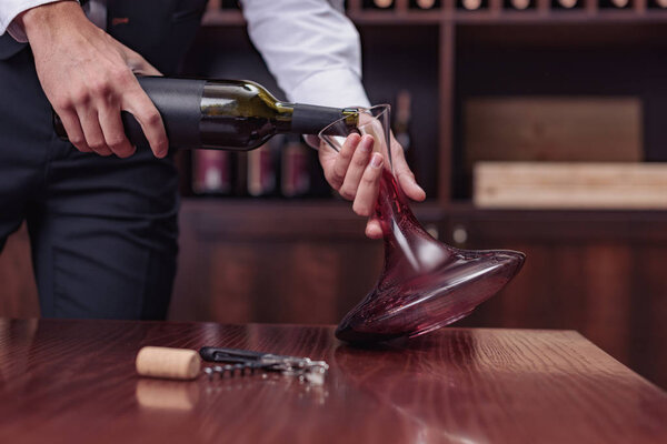 sommelier pouring red wine