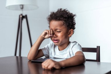 Tablet ile otururken ağlayan çocuk