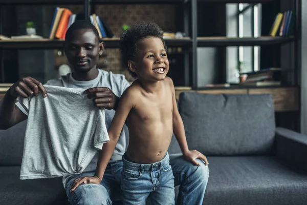 Padre vistiendo a su hijo — Foto de Stock