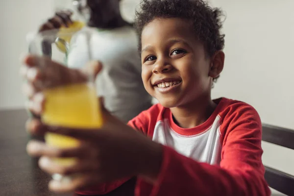 Niño con vaso de jugo de naranja — Foto de Stock