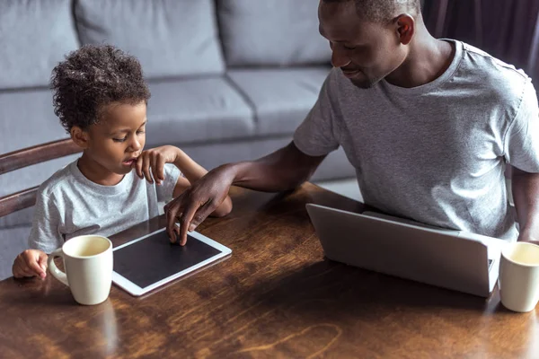 父と息子のラップトップとタブレットを使用して — ストック写真