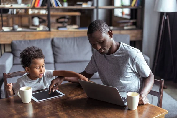 Vader en zoon met laptop en tablet — Stockfoto