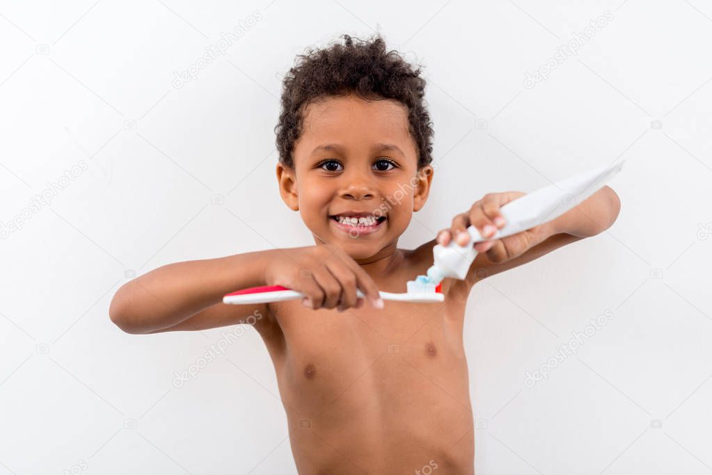 kid applying tooth paste on brush