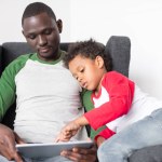 Ojciec i syn przy użyciu komputera typu tablet