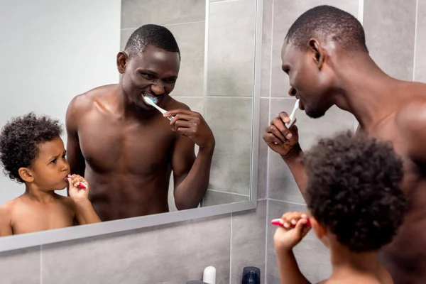 Father and son brushing teeth — Stock Photo, Image