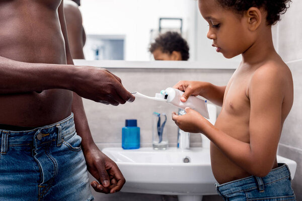 father and son brushing teeth