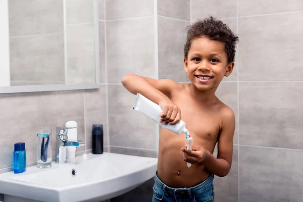 Kind tandpasta op de borstel toepassen — Stockfoto
