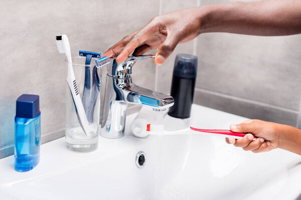 father and son washing tooth brush