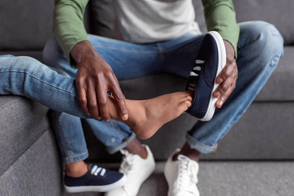 Father putting shoes on son — Stock Photo, Image