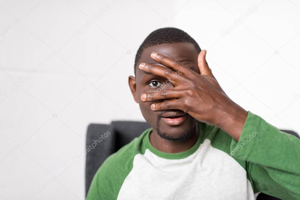man covering face with hand