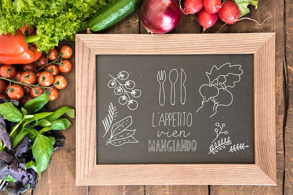 chalkboard with group of fresh vegetables 