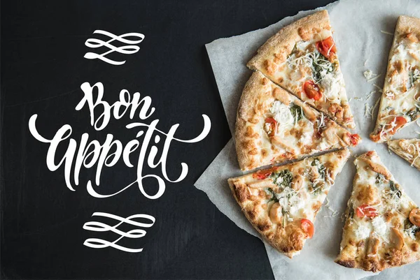 Traditionele Italiaanse pizza gesneden op perkament — Stockfoto