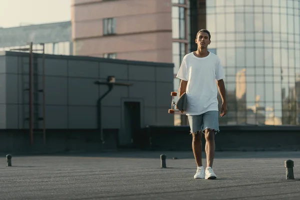 Uomo che cammina con skateboard — Foto Stock