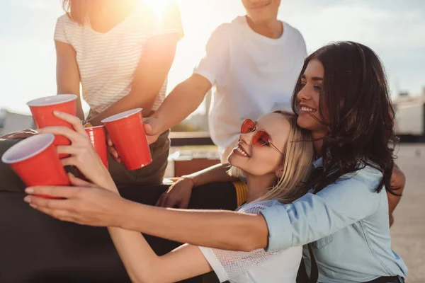 Friends clinking with plastic cups — Stock Photo, Image