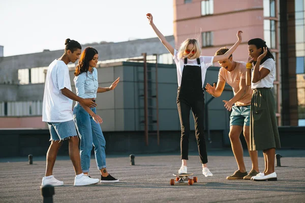 Dívka na koni skateboard na střeše — Stock fotografie