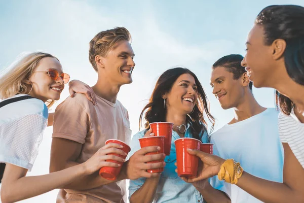 Friends clinking plastic glasses — Stock Photo, Image