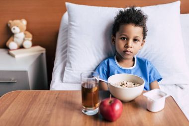 african american boy with breakfast in clinic clipart