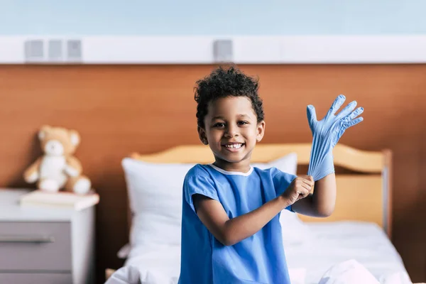 Afro-Amerikan çocuk medikal eldiven giyiyor — Stok fotoğraf
