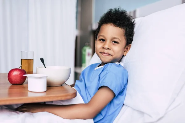 Garçon afro-américain avec petit déjeuner en clinique — Photo