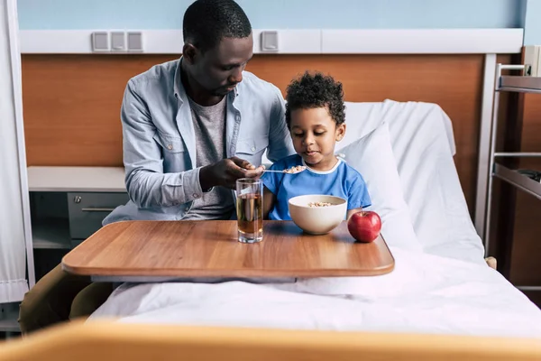 Afrikaanse Amerikaanse vader voeding zoon — Stockfoto