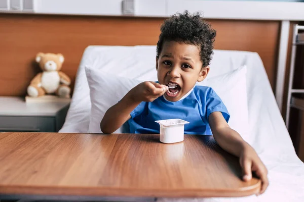 African american boy eating yogurt — Stock Photo, Image