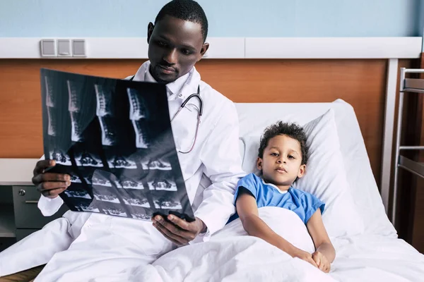 Afro-Amerikaanse arts en patiënt met xray foto — Stockfoto
