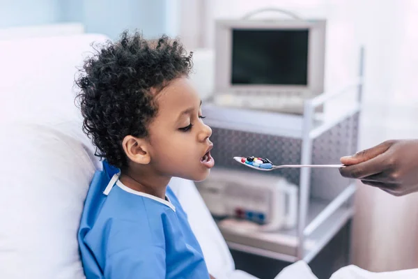 Afro-americano menino tomando medicamentos — Fotografia de Stock