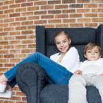 Broers en zussen rustend op fauteuil