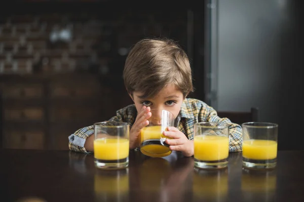 Criança à mesa com copos de suco — Fotografia de Stock