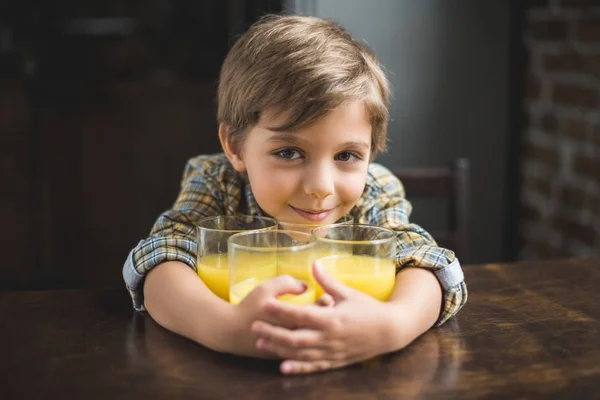 Criança à mesa com copos de suco — Fotografia de Stock