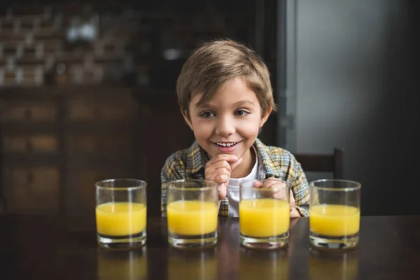 Мальчик со стаканами сока — стоковое фото
