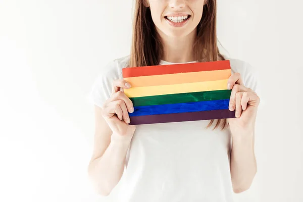 Mujer sosteniendo pequeña bandera del arco iris — Foto de Stock