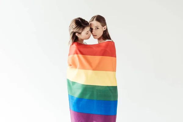 Lesbianas pareja envuelta en arco iris bandera — Foto de Stock