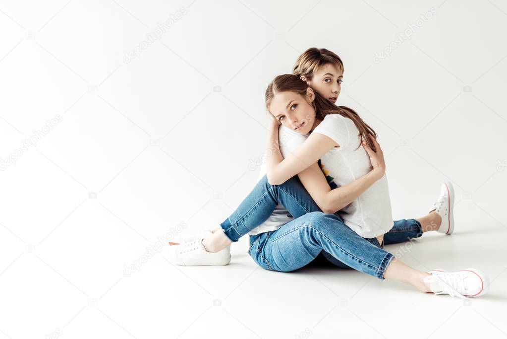 Lesbians hugging and sitting on floor
