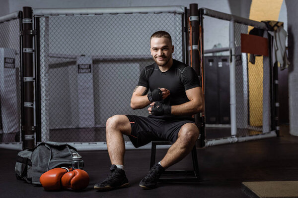 боксер обвязывает руки бинтами
