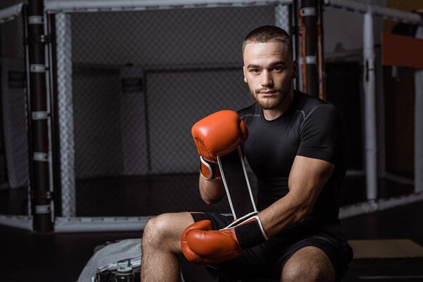 мускулистый спортсмен в боксёрских перчатках
