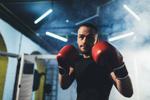 мускулистый спортсмен в боксёрских перчатках
