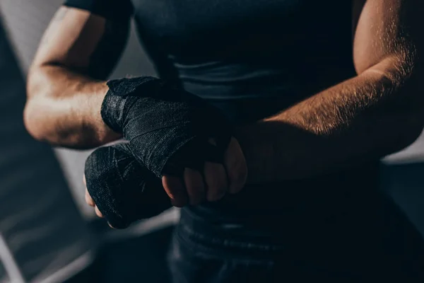 Boxer wrapping hands with bandages — Free Stock Photo