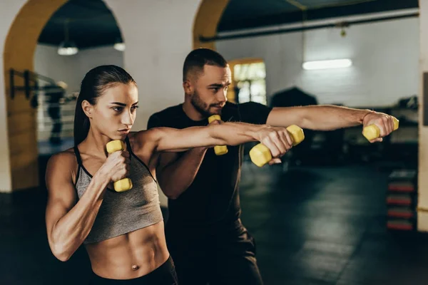 Coppia atletica che si esercita con i manubri — Foto Stock