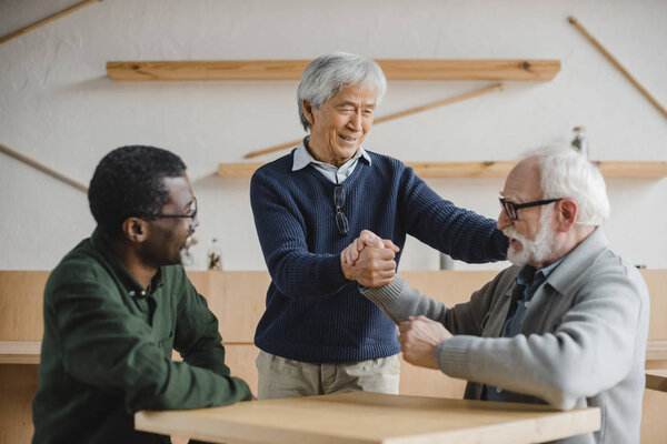 senior friends greeting in cafe