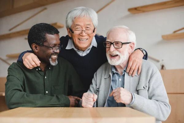 Senior vänner embracing i bar — Stockfoto