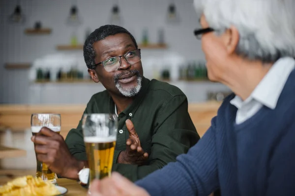 Senior friends talking and drinking beer — Stock Photo, Image